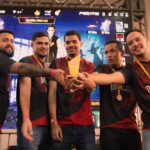 Zespół graczy e-sportowych świętuje zwycięstwo z pucharem
