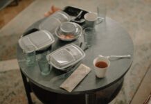 Jak zaplanować menu, żeby następne danie wykorzystywało resztki po poprzednim Stół z pojemnikami po jedzeniu na wynos i brudnymi naczyniami