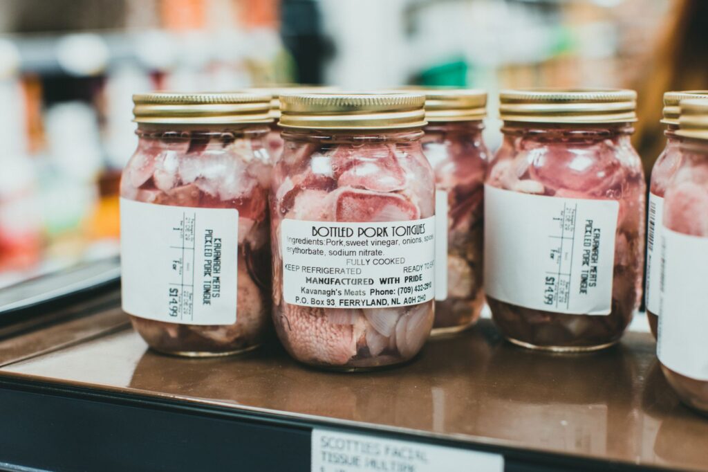Słoiki z konserwowanymi ozorkami wieprzowymi na półce supermarketu
